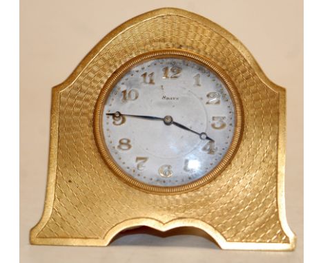 A mid-20th century gilt metal cased engine turned easel travel clock, having enamelled dial with Arabic numerals and eight da