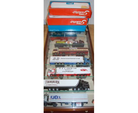 A framed and glazed display case containing a collection of various Corgi Tekno and other road haulage diecasts to include Ge