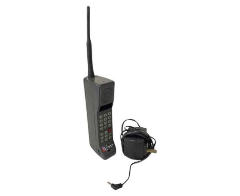 Vintage Motorola Cellphone and Charger. Grey coloured body and label says 'MOTOROLA Independent'Height to top of aerial 33 cm
