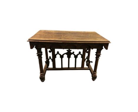 An Oak Gothic Carved Table, Mid 19th Century. Carved arch detail to borders, turned corinthian column legs, and a central cro