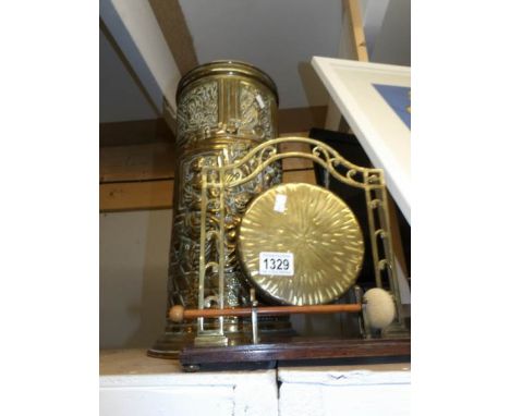 A brass dinner gong and a brass stick stand.