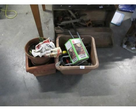 A terracotta planter, pots and gardening tools
