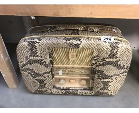 A vintage De Luxe radio with faux snake skin case