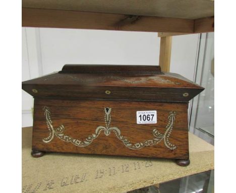 A Victorian rosewood tea caddy with mother of pearl inlay.