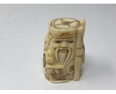 A carved Chinese bone netsuke  - Gentleman carrying a staff and scroll