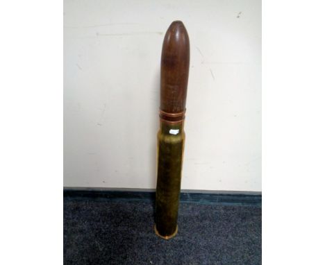 A brass ammunition shell casing with wooden point, height 84 cm  