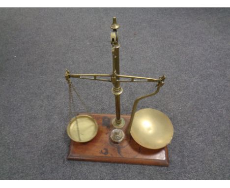 A set of 19th century brass balance scales with weights mounted on a mahogany board  