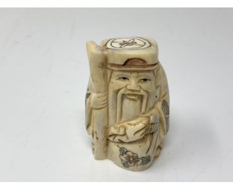 A carved Chinese bone netsuke  - Gentleman carrying a sack of corn