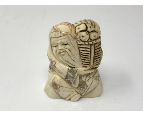 A carved Chinese bone netsuke  - Village elder carrying a basket of food
