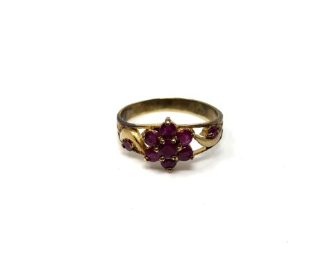 A ruby cluster ring on yellow metal shank, size T