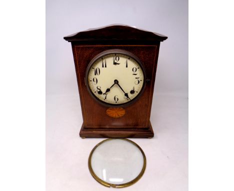 An inlaid mahogany American mantel clock on raised brass feet (door a/f)