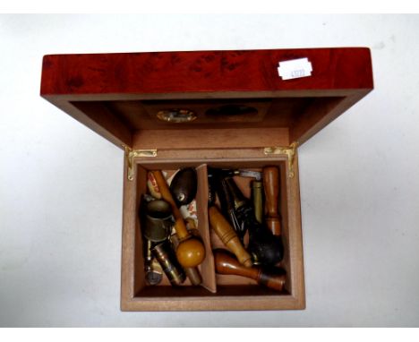 A humidor containing miscellaneous to include bullet bottle opener, cigar cutters, shot measuring tools etc  