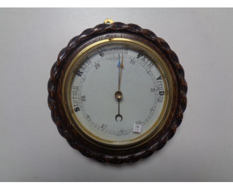 A carved oak circular barometer  
