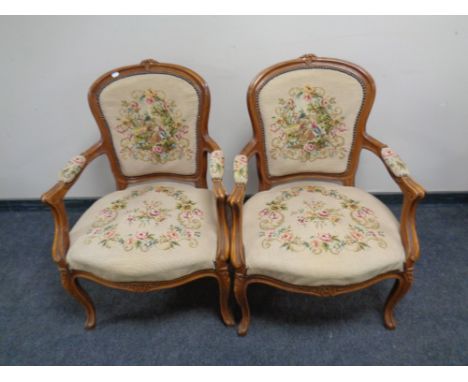 A pair of carved beech French salon armchairs upholstered in a tapestry fabric  
