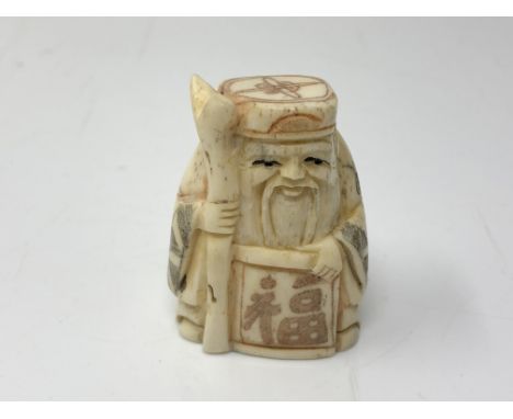 A carved Chinese bone netsuke  - Gentleman carrying a scroll