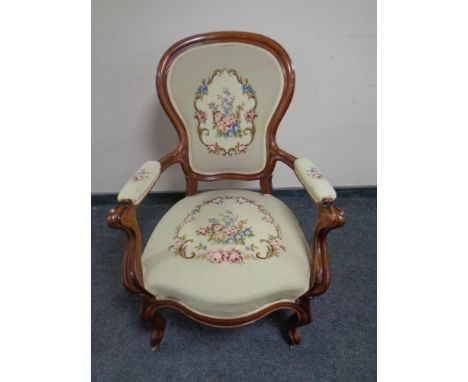 A carved beech framed French salon armchair upholstered in a tapestry fabric  