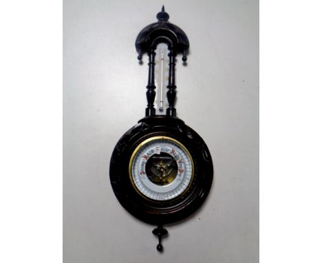 A carved ebonised barometer with enamel dial  