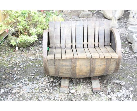 A BOURBON WHISKEY BARREL GARDEN BENCH with barrel staves as seat, back and feet, length 88cm