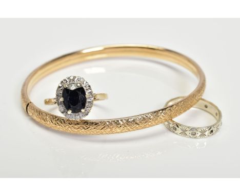 A 9CT GOLD BANGLE AND TWO RINGS, the hollow flexible bangle with diamond cut engraved decoration, the first ring a sapphire a