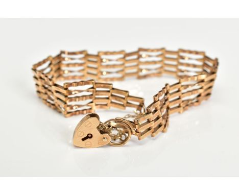 A YELLOW METAL GATE BRACELET, links with twist design, fitted with a gold heart padlock clasp, approximate length 160mm, clas
