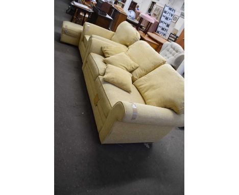 A three piece yellow suite comprising a two seater sofa, armchair and matching footstool