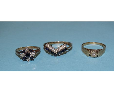 A sapphire and diamond point cluster ring, a sapphire and synthetic white stone wishbone ring and a solitaire diamond ring, a