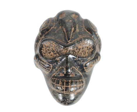 Taino portrait head made of magnetite and having positive field. A bird embraces the head of the shaman while a dog head “gho