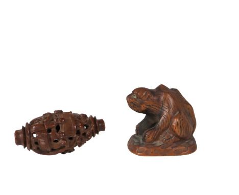 A Japanese carved wood netsuke of a cat, and an intricately carved wooden bead.