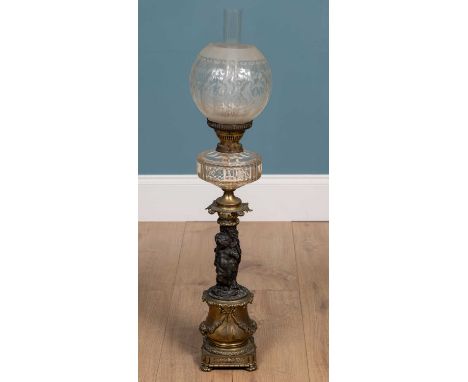 Antique brass and spelter oil lamp with glass shade and reservoir, the support cast with classical putti, baskets of fish and