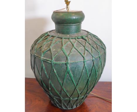A large baluster-shaped green-painted tin lamp with woven latticework-effect decoration in relief together with matching coni