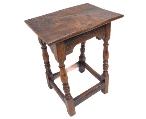A high 17th century style oak joint stool; the slightly concave top above baluster turned supports united by stretchers (45cm