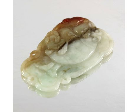 A Chinese carved jade pendant, modelled in low relief with lion eating its tail on a gourd, the reverse with leaves, 4.5cm 