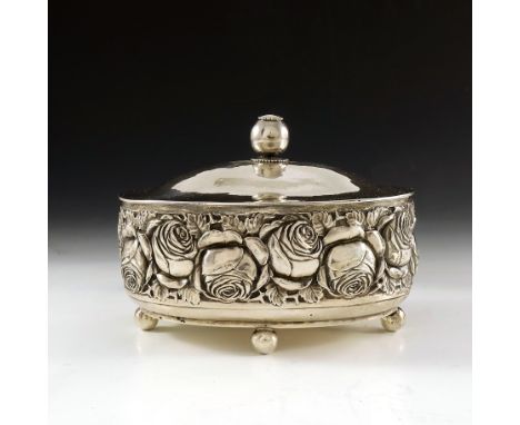 A Secessionist silver caddy or casket, A Lang, circa 1920, oval section, embossed with roses, the planished ogee domed lid wi