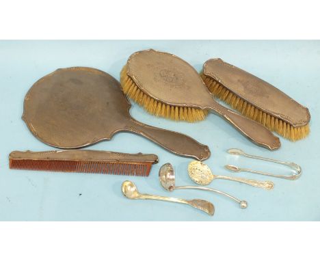 A silver four-piece dressing table set, comprising mirror, two brushes and a comb, with engine-turned, scroll and floral engr