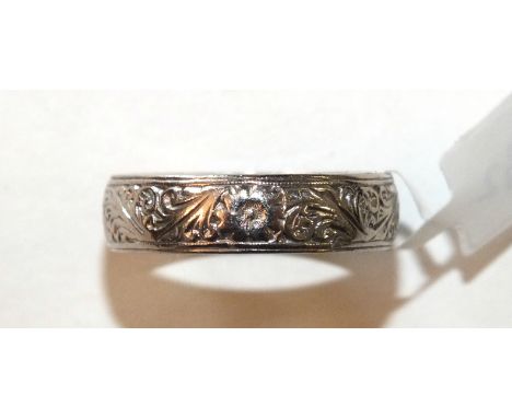 An 18ct white gold wedding band with carved floral and scroll decoration, 6mm wide, size R, 6g.