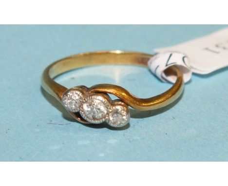 A three-stone diamond crossover ring in 18ct yellow and white gold mount, size K, 1.9g.