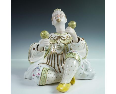 Large porcelain nodder figurine depicting a seated juggler, crafted with elaborate attention to detail. The figure features W