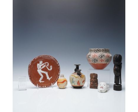 A diverse and intriguing collection of cultural and artistic pieces, including hand-crafted pottery, porcelain, and carved wo