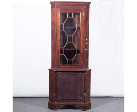Reproduction mahogany effect free-standing corner cabinet, Georgian style, dentil cornice above glazed panel door, enclosing 