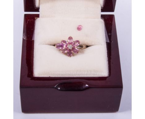 A pink sapphire and diamond dress ring, eight oval pink sapphires arranged as a floral cluster with a diamond to the centre, 