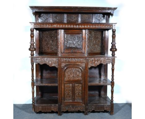 Joined oak court cupboard, in part 18th Century, the upper section with a carved cornice, scrolled brackets above five lozeng