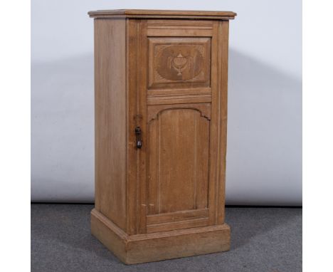 Late Victorian oak pedestal cupboard, rectangular top with a moulded edge, carved panelled door enclosing a shelf, plinth bas