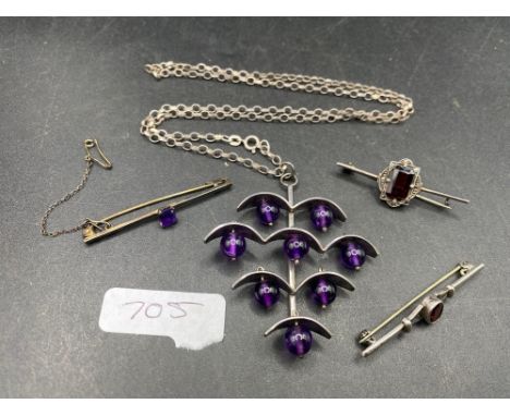 Three silver target brooches and a silver designer amethyst necklace