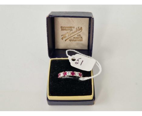 A WHITE GOLD RUBY AND DIAMOND HALF ETERNITY RING 18CT GOLD APPROX 0.50 CARATS SIZE O 2.7 GMS BOXED