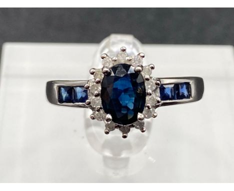 A sapphire and diamond cluster ring with calibrated sapphire shoulders size N set in gold 1.6 gms