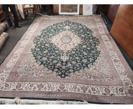 A green ground oriental carpet, 14ft x 10ft