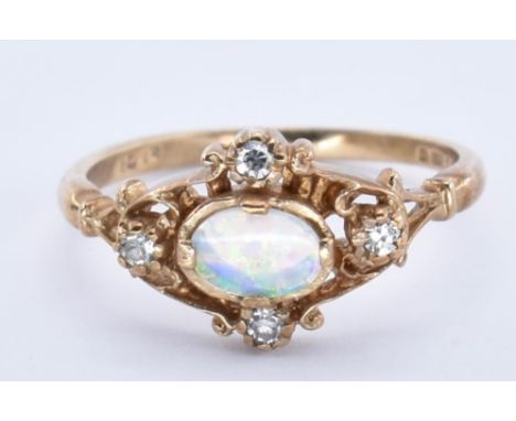 A hallmarked 9ct gold opal and diamond ring. The ring set with a central oval cut opal cabochon surrounded by 4 single cut di