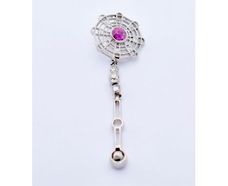 A Burmese ruby and diamond drop pendant. White gold with pierced drop to 3 round cut diamonds having a pierced setting with c