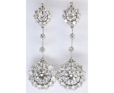 A pair of 18ct gold platinum and diamond cluster drop earrings. The earrings set with central round brilliant cut diamonds fr