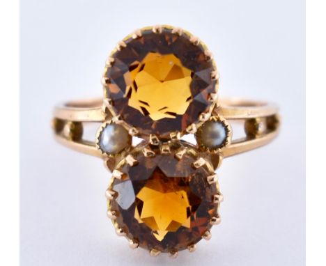 An antique French 18ct gold citrine and pearl ring. The ring set with two round cut citrine having two pearl accents to bifur